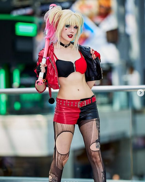 Harley Quinn cosplay with red-black outfit at convention, portrayed by Meggie