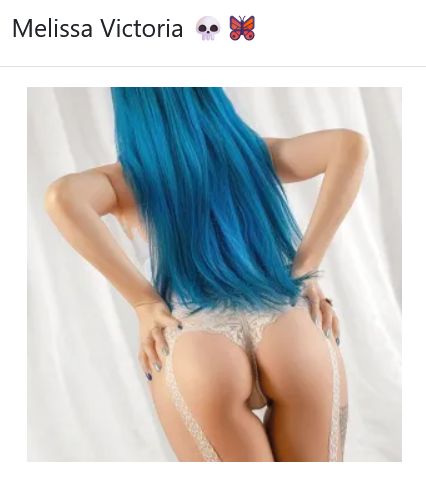 Melissa Victoria with long blue hair, lace lingerie, and garter straps from behind